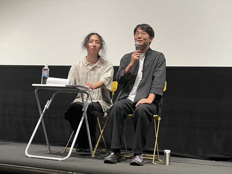 マイクで話すグー・シャオガン監督