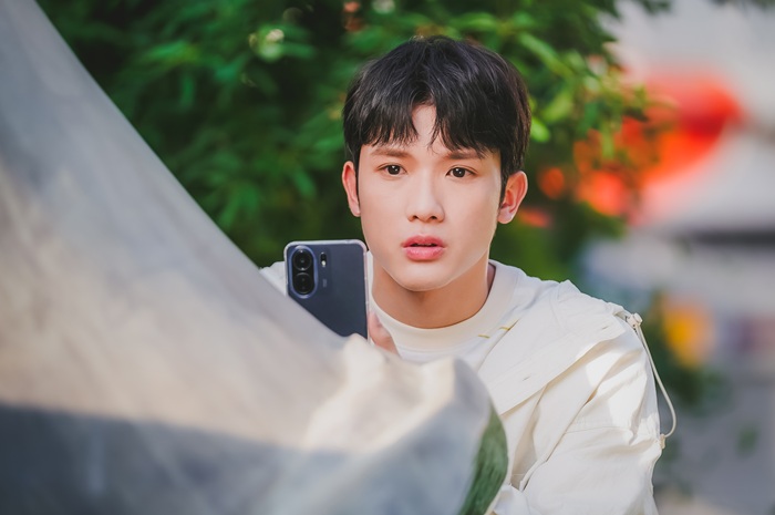 スマホをかまえるジー・チョンハオ